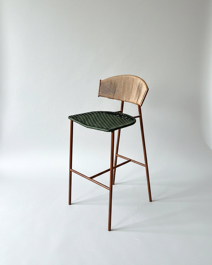 Butaco Sabina Artesanal de Geometrico: estructura metálica, espaldar en fibra de madera y asiento en mimbre sintético tejido a mano.