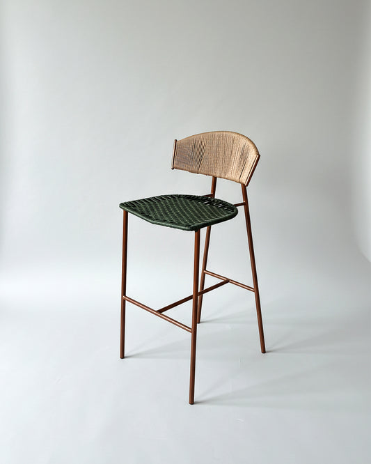 Butaco Sabina Artesanal de Geometrico: estructura metálica, espaldar en fibra de madera y asiento en mimbre sintético tejido a mano.